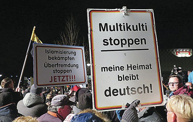 Signs are held up at a rally on Monday in Dresden, Germany. The one on the left reads “Fight Islamization, stop the flood of foreigners now.” The one on the right “Stop multiculturalism. My homeland will stay German.” Claudia Himmelreich/McClatchy DC/TNS