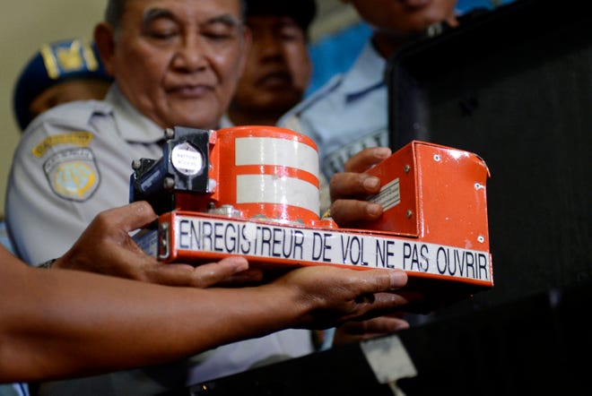 Head of Indonesian National Transportation Safety Committee Tatang Kurniadi, center, shows the newly recovered Cockpit Voice Recorder from the ill-fated AirAsia Flight 8501 during a press conference Tuesday in Pangkalan Bun, Central Borneo, Indonesia. Divers retrieved the crashed AirAsia plane's second black box from the bottom of the Java Sea on Tuesday, giving experts essential tools to piece together what brought Flight 8501 down.