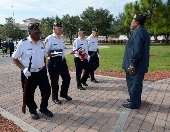 Members of The American Legion Post 71 Honor Guard carry the American and POW/MIA flags past Lake Wales Mayor Eugene Fultz during a flag rededication ceremony Tuesday at Lake Wales City Hall. The flags were found on the ground Christmas Day after a rope failed.