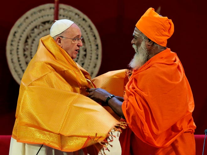 Sri Lankan Hindu priest Kurakkal Somasundaram, right, presents a shawl to Pope Francis during an inter-religious meeting in Colombo, Sri Lanka, Tuesday, Jan. 13, 2015. Pope Francis arrived in Sri Lanka Tuesday at the start of a weeklong Asian tour saying the island nation can't fully heal from a quarter-century of ethnic civil war without pursuing truth for the injustices committed.
