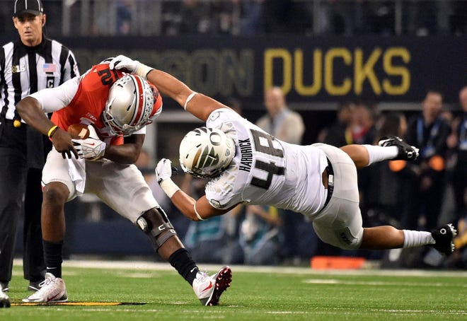 Cardale Jones slides out of a tackle by Oregon linebacker Rodney Hardrick. Jones rushed for 38 yards and a touchdown for the Buckeyes on Monday night. (Brian Davies/The Register-Guard)