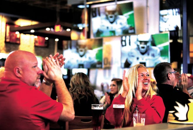 Dave Kreider and Robyn Worthington, both of New Philadelphia, cheer on the Ohio State Buckeyes as they watch the national championship game at Buffalo Wild Wings in New Philadelphia on Monday night.