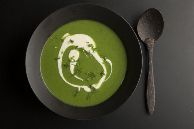 A leek soup garnished with creme fraiche, chives and tarragon