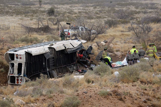 Officials investigate the scene of a prison transport bus crash in Penwell, Texas.