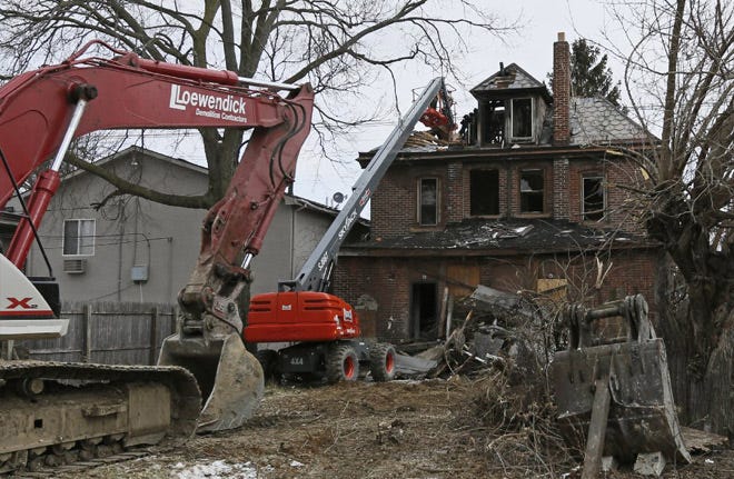 Loewendick Demolition Contractors work to tear down the chimney from 1239 Summit Street in Weinland Park before bulldozing the entire house.