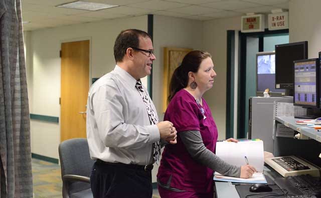 Dr. Ron Allison, medical director of 21st Century Oncology, and Morgan Carter, radiation therapy technician, review patient information Tuesday at Lenoir Memorial Cancer Center/Radiation Oncology.