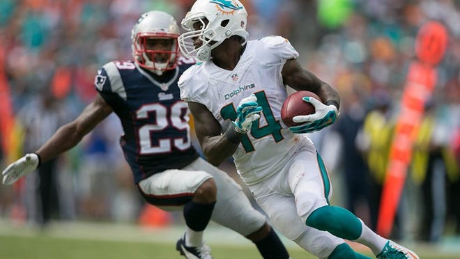 Miami Dolphins wide receiver Jarvis Landry (14) returns a punt as New England Patriots defensive back Don Jones (29) defends at Sun Life Stadium in Miami Gardens, Florida on September 7, 2014. (Allen Eyestone / The Palm Beach Post)