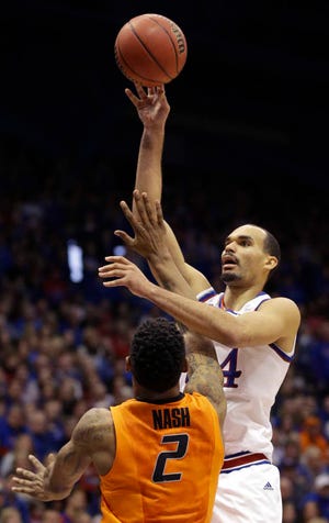 Kansas forward Perry Ellis (34) shoots over Oklahoma State forward Le'Bryan Nash (2) during the first half of an NCAA college basketball game at Allen Fieldhouse in Lawrence, Kan., Tuesday, Jan. 13, 2015. (AP Photo/Orlin Wagner)