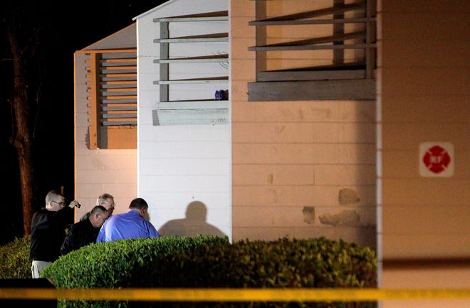 Officials investigate the scene of a shooting at The Grove Villas apartment complex on Wednesday, Jan. 14, 2015 in Gainesville.