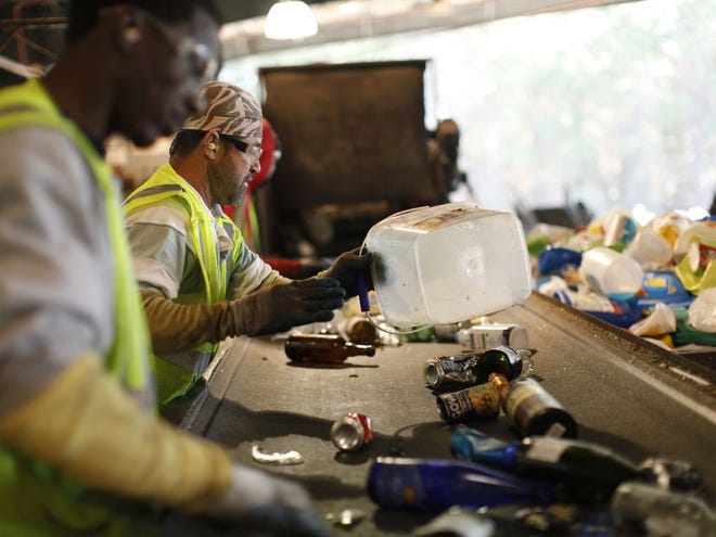 Workers on the commingle sort line separate the day’s haul of curbside recycled materials at the Leveda Brown Environmental Park, which has recently changed control from a contracted company to Alachua County.