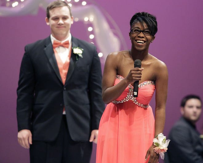 Miss Massillonian candidate Demetria Anthony has some fun with the question and answer portion during the formal assembly of the Miss Massillonian and Outstanding Senior Boy contest as her escort and Outstanding Senior Boy candidate Joseph Easley Jr. waits his turn.