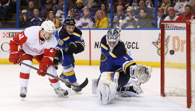 Detroit Red Wings left wing Tomas Tatar, left, scores past St. Louis Blues goaltender Brian Elliott during the second period of an NHL hockey game Thursday, Jan. 15, 2015, in St. Louis. Blues' Jay Bouwmeester helps on defense. The Red Wings won 3-2 in overtime.