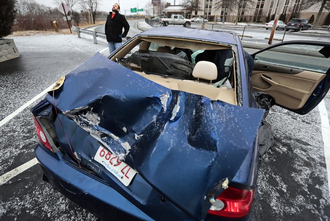 Brian Carvalho stretches after his car rolled over Thursday morning on Interstate 195 East in Westport. Black ice caught people off guard all day. PETER PEREIRA/THE STANDARD-TIMES