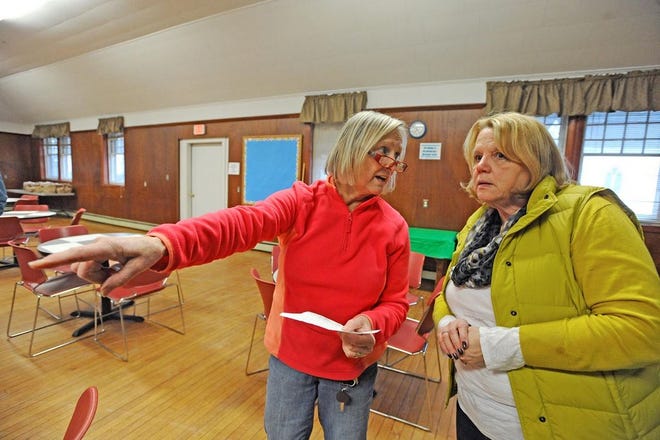 Michaeline Saladyga, left, and Wendy Berry, directors of Taunton Area Community Table, help set up St. John's Parish hall for family café evening.