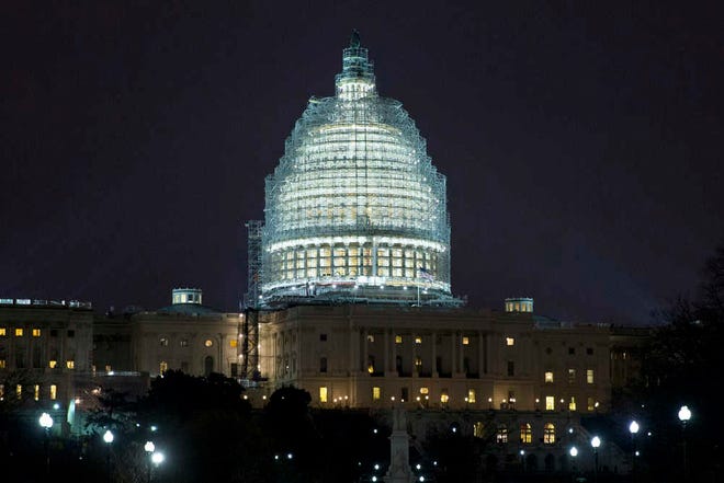 Lights illuminate the U.S. Capitol, which is covered in scaffolding for restoration, in Washington on Wednesday, Jan. 14, 2015. A man who plotted to attack the Capitol and kill government officials inside it and spoke of his desire to support the Islamic State militant group was arrested on Wednesday, the FBI said. (AP Photo/Jacquelyn Martin)