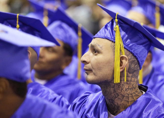 At graduation ceremonies last month, inmate Richard Chavez Jr., complete with mortarboard and gown, and fellow Prison Entrepreneurship Program students listen to the commencement speaker before getting their diplomas.
