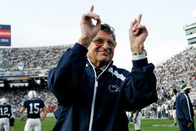 FILE - In this Nov. 5, 2005, file photo, Penn State football coach Joe Paterno acknowledges the crowd before an NCAA college football game against Wisconsin in State College, Pa.  A proposed settlement, announced Friday, Jan. 16, 2015, by the NCAA, will give Penn State back 112 football team wins that were vacated two years ago in the Jerry Sandusky child molestation scandal. If approved, the new agreement also would restore former coach Paterno's status as the winningest coach in major college football history with 409 victories. (AP Photo/Carolyn Kaster, File)