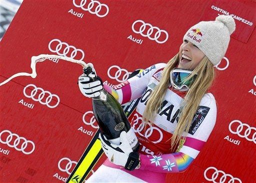 Lindsey Vonn sprays sparkling wine on the podium after winning an alpine ski, women's World Cup downhill, in Cortina d'Ampezzo, Italy, Sunday, Jan. 18, 2015. Lindsey Vonn won a downhill Sunday to match Annemarie Moser-Proell's 35-year-old record of 62 World Cup wins, capping a comeback from two serious knee surgeries.