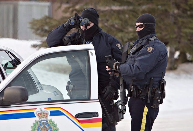 Police search for a suspect in the shooting of two RCMP officers Saturday in 
St. Albert. The suspect was later found dead in a home. Officials did not 
say whether he had killed himself, but officers reportedly did not fire 
their weapons in the home.AP PHOTO / JASON FRANSON