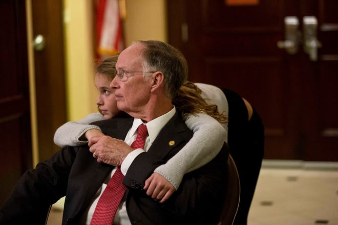 FILE - In this Nov. 4, 2014, file photo, Republican Gov. Robert Bentley and his granddaughter Taylor Bentley watch his opponent, Democrat Parker Griffith, speak on television after the announcement of Bentley's re-election for Alabama governor in Montgomery, Ala. Bentley says the revenue-raising package he plans to present early in his second term will likely cause him to pay more taxes. (AP Photo/Brynn Anderson, File)