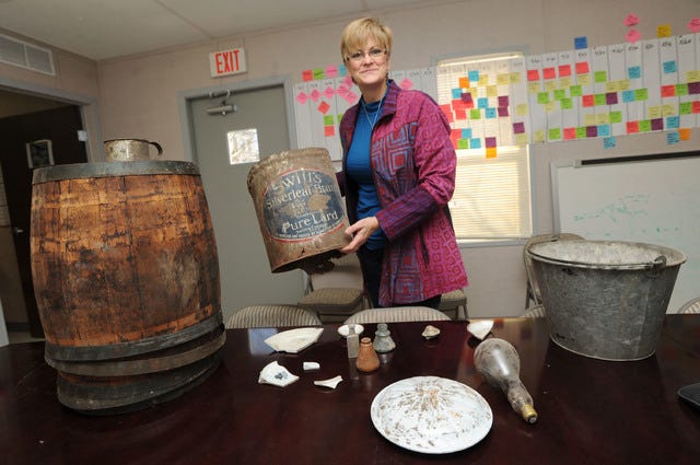 Kerry Dixon, project manager of the Marston Hall renovation, shows artifacts from decades ago, including from the construction of the building in the early 1900s at Iowa State University on Friday, Jan. 16, in Ames. The lard bucket she is holding likely comes from the 1930s. Photo by Nirmalendu Majumdar