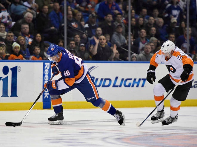 New York Islanders left wing Nikolay Kulemin (86) drives the puck past Philadelphia Flyers right wing Matt Read (24) to score in the second period of an NHL hockey game.