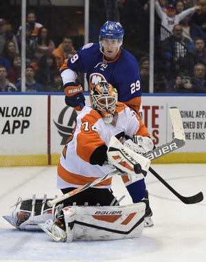 Islanders center Brock Nelson keeps his eyes on the puck stopped by Flyers goalie Rob Zepp during Monday's game.