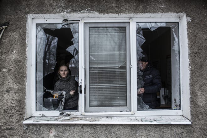 A Ukrainian man and woman look through a broken window in an apartment hit by Ukrainian artillery near the center of Donetsk. Clashes between troops and rebels continued on Sunday.