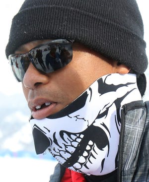 Tiger Woods walks in the finish area of an alpine ski, women's World Cup super-G, in Cortina d'Ampezzo, Italy, on Monday, Jan. 19, 2015.