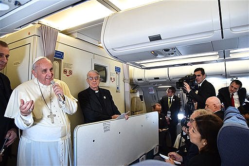 Pope Francis, second left, gestures as he talks with journalists during his flight from Manila to Rome, Monday, Jan. 19, 2015. Pope Francis flew home Monday after a weeklong trip to Asia, where he called for unity in Sri Lanka after a civil war and asked Filipinos to be "missionaries of the faith" in the world's most populous continent after a record crowd joined his final Mass in the Philippine capital. (AP Photo/Giuseppe Cacace, pool)