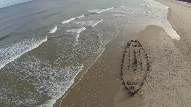 Artist Silas Finch created a ship sculpture from chunks of peat found on Nauset Beach in Orleans. The art project lasted about three hours, until the returning tide swamped it. Screen capture courtesy Justin Lynch/Swellfleet Productions