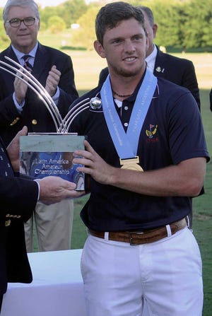 Chile's Matias Dominguez receives the Latin American Amateur Championship trophy at the Pilar Golf Club in Buenos Aires, Argentina, Sunday Jan. 18, 2015. With a spot in the Masters riding on the outcome, Dominguez closed with a 1-under 71, winning the inaugural event and earning the right to be among Rory McIlroy, Tiger Woods and his golfing idol, Phil Mickelson, in April. (AP Photo/Emmanuel Fernandez)