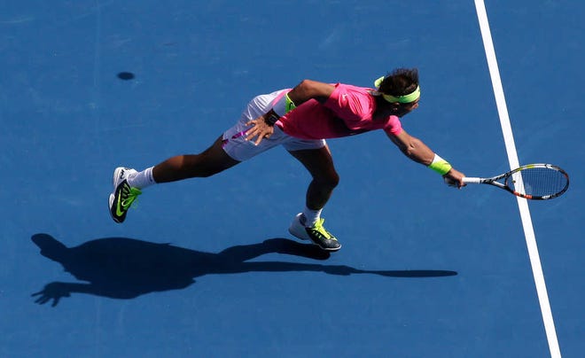 Rafael Nadal of Spain reaches for a shot from Mikhail Youzhny of Russia during their first round match at the Australian Open tennis championship in Melbourne, Australia, Monday, Jan. 19, 2015. (AP Photo/Bernat Armangue)