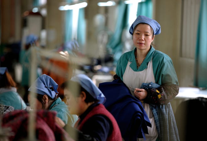 Women work at a garment factory in Huaibei in central China's Anhui province Tuesday.