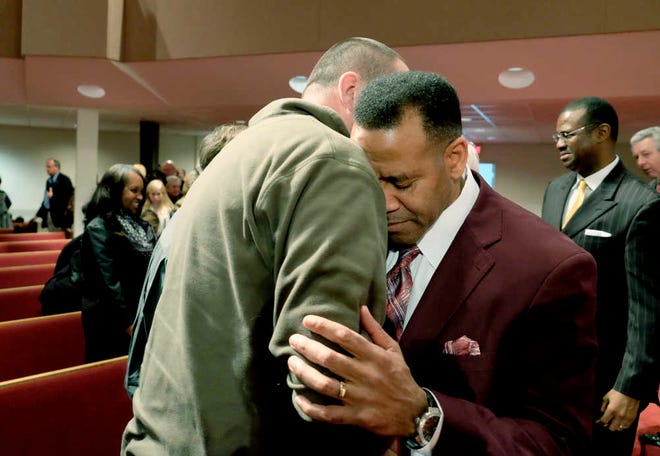 Mike Russell (left) has a quick prayer with former Atlanta Fire Chief Kelvin Cochran after Cochran spoke at Abilene Baptist Church on Sunday.