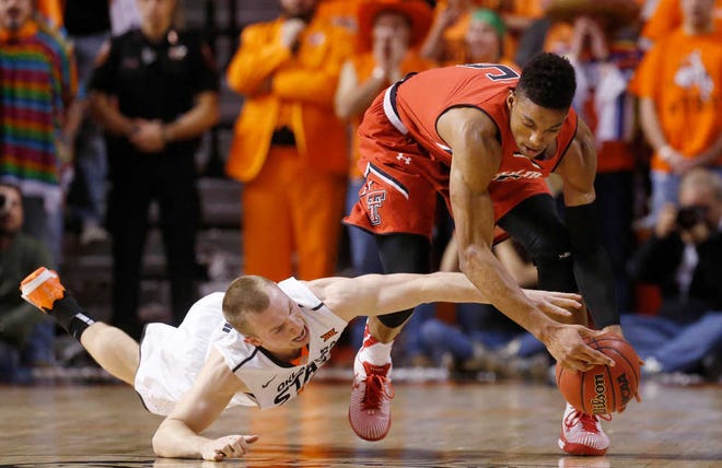 Oklahoma State guard Phil Forte, left, reaches for the ball with Texas Tech forward Justin Gray, right, in the first half of an NCAA college basketball game in Stillwater, Okla., on Wednesday, Jan. 21, 2015.