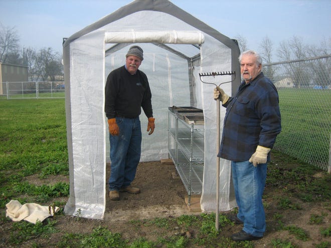 Escalon Sunrise Rotary members Doug Alcorn and Jordon Freitas put finishing touches on the greenhouse shelving.