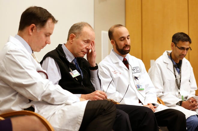 Brigham and Women's Hospital doctors, from the left, Primary Care Physician Charles Morris, Interventional Cardiologist Andrew Eisenhauer, Thoracic Surgeon Daniel Wiener, and Interventional Cardiologist Pinak Shah, appear emotional as they face members of the media Wednesday, while remembering Michael J. Davidson, director of endovascular cardiac surgery at the hospital, in Boston. Officials at the hospital said Davidson died late Tuesday after being fatally wounded around 11 a.m. by a gunman who then killed himself.