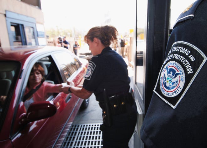 FILE - In this June 21, 2005, file photo, U.S. Customs and Border Protection Inspector Maria Arreola checks an electronic ID card at one of two new Secure Electronic Network for Travelers Rapid Inspection lanes at the San Ysidro Port of Entry in San Diego.