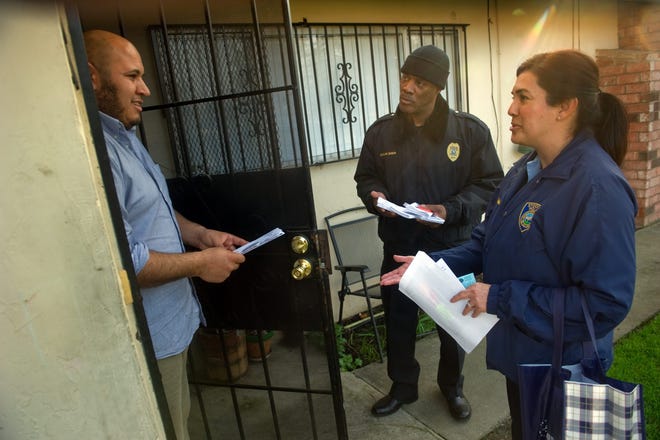Community Service Officer Rosie Calderon, center, and Police chaplain Damon Bridges, who are members of the newly formed Stockton Police Department's Neighborhood Impact Protocol Team, talk with resident Alfonso Ramos at the Louis Park Estates apartment complex where the body of a unborn child was found in a dumpster earlier this month. It is the mission of the team, consisting of community service officers, police chaplains and Sentinel cadets, to canvas neighborhoods that have experienced traumatic events to tell residents about police porgeramas and who to call to report a crime. CLIFFORD OTO/THE RECORD