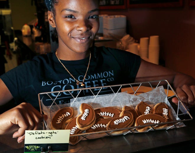 In this Jan. 21, 2015 photo, Ashleigh Fuller shows off "Deflate-gate" cookies for sale at Boston Common Coffee in Boston's North End neighborhood. As the NFL investigates how footballs got deflated during the New England Patriots' AFC Championship game, and detractors accuse the team of cheating, very little air seems to have gone out of Patriots Nation and its Super Bowl euphoria. 

AP Photo/Elise Amendola