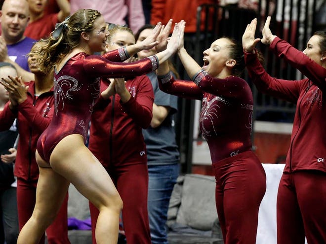 Alabama’s Lora Leigh Frost high-fives her teammates after competing on the floor exercise during Friday’s meet against No. 1 Florida at Coleman Coliseum. No. 7 Alabama won, 197.4 to 196.8.