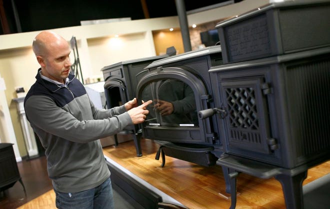 At August West Fireplaces in Pembroke, operations manager Curt Ludlow shows off some of the best selling wood stoves for residential use, Tuesday, Jan. 6, 2015.