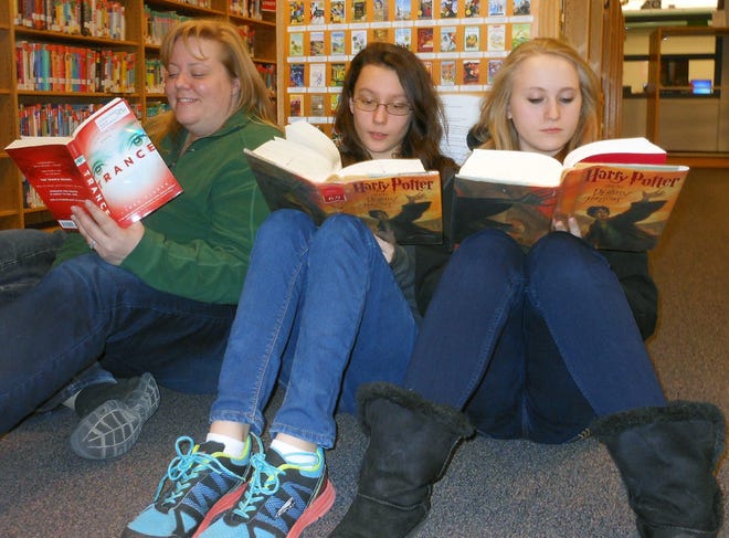 Students and teachers at Little Falls Middle School took some time to read as part of a “reading party” on Friday. Pictured from left are seventh-grade teacher Shannon Rodger and eighth-grade students Rachel VanOrden and Rebecca LaVenture. TIMES PHOTO/STEPHANIE SORRELL-WHITE
