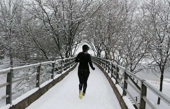 A jogger crosses a footbridge Saturday in Boston as a winter storm strikes 
the region. Snow was reported in parts of Massachusetts, Pennsylvania, New 
York, New Jersey and Connecticut.AP PHOTO / MICHAEL DWYER