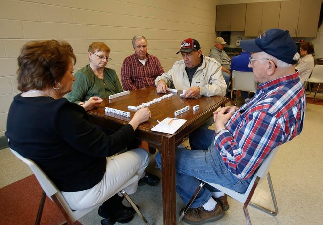 From left, Carolyn Akridge, Dene Price, Robert Seale, Ray Shuttlesworth, and Paul Jones play a round of dominoes on Friday at the Leroy McAbee Center, the new location for Focus on Senior Citizens of Tuscaloosa County.