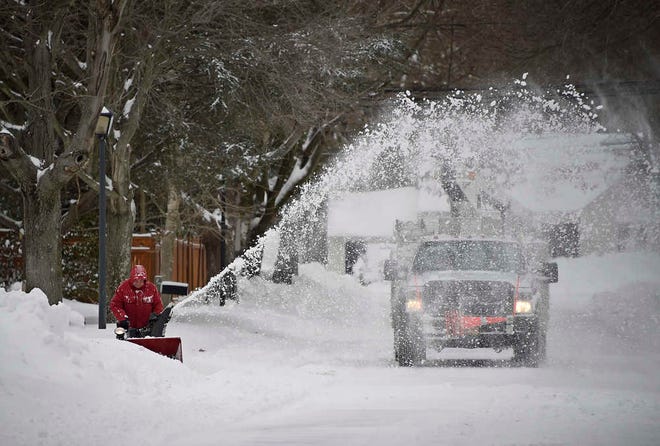 Ted Diamond sprays snow onto Greenvale Drive while clearing out his driveway in East Northport on Tuesday in New York. Long Island was one of several areas throughout the state to be hit by a blizzard overnight. The Boston area was also heavily hit with snow.