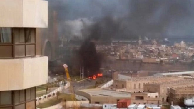 In this image made from video posted by a Libyan blogger, the Cortinthia Hotel is seen under attack in Tripoli, Libya.