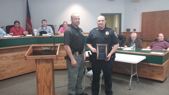 Photo courtesy of the City of Rincon Rincon Police Chief Phillip Scholl presents Detective Donald Wood a plaque for being selected as the 2014 Officer of the Year. The presentation was made a recent council meeting.