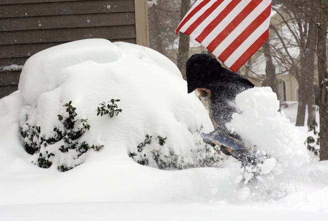 A strong wind blows as Carla Navickas clears her sidewalk in Colchester Tuesday during a blizzard. 

John Shishmanian/ NorwichBulletin.com
